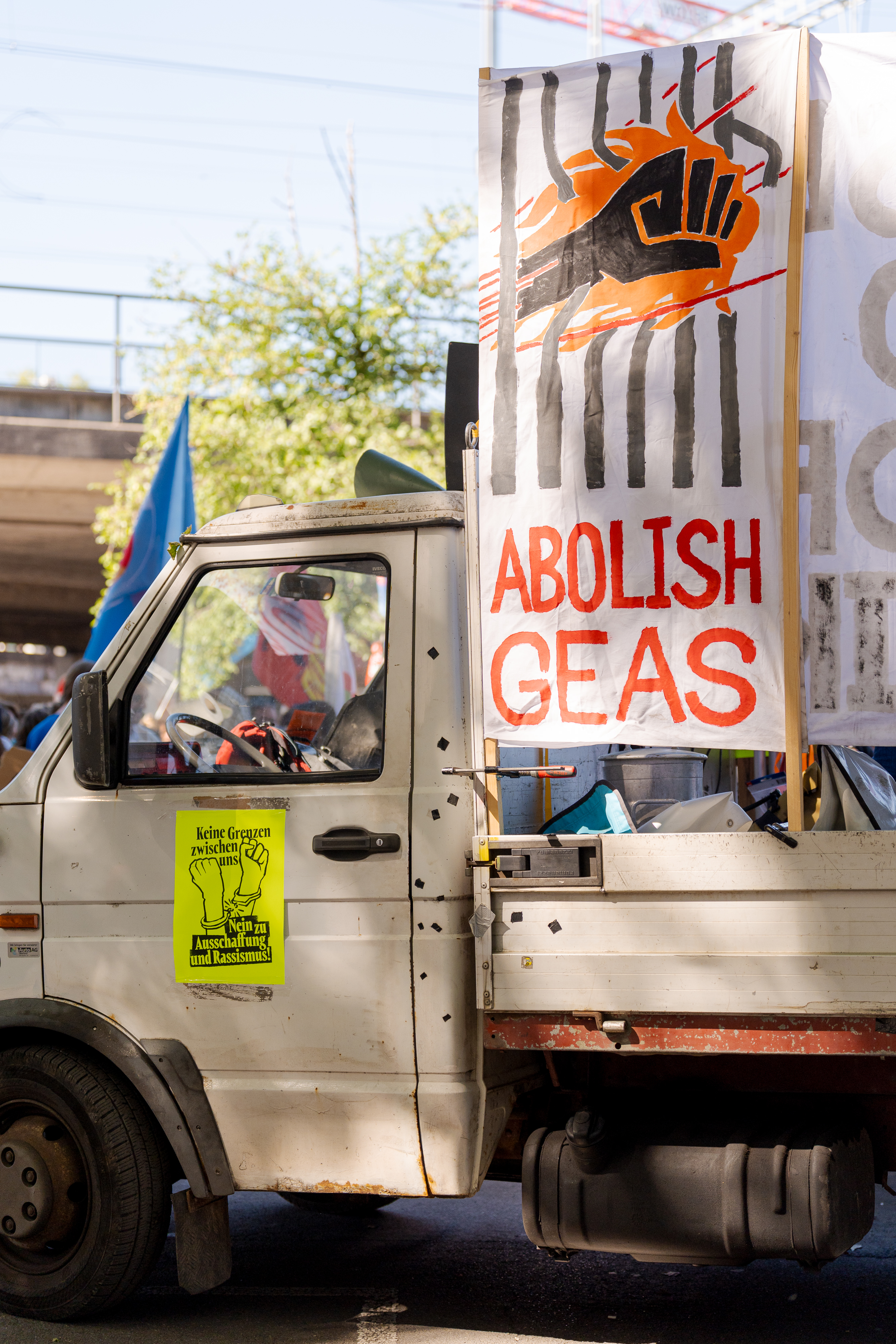 Bus de manif avec banner "Abolish GEAS"
