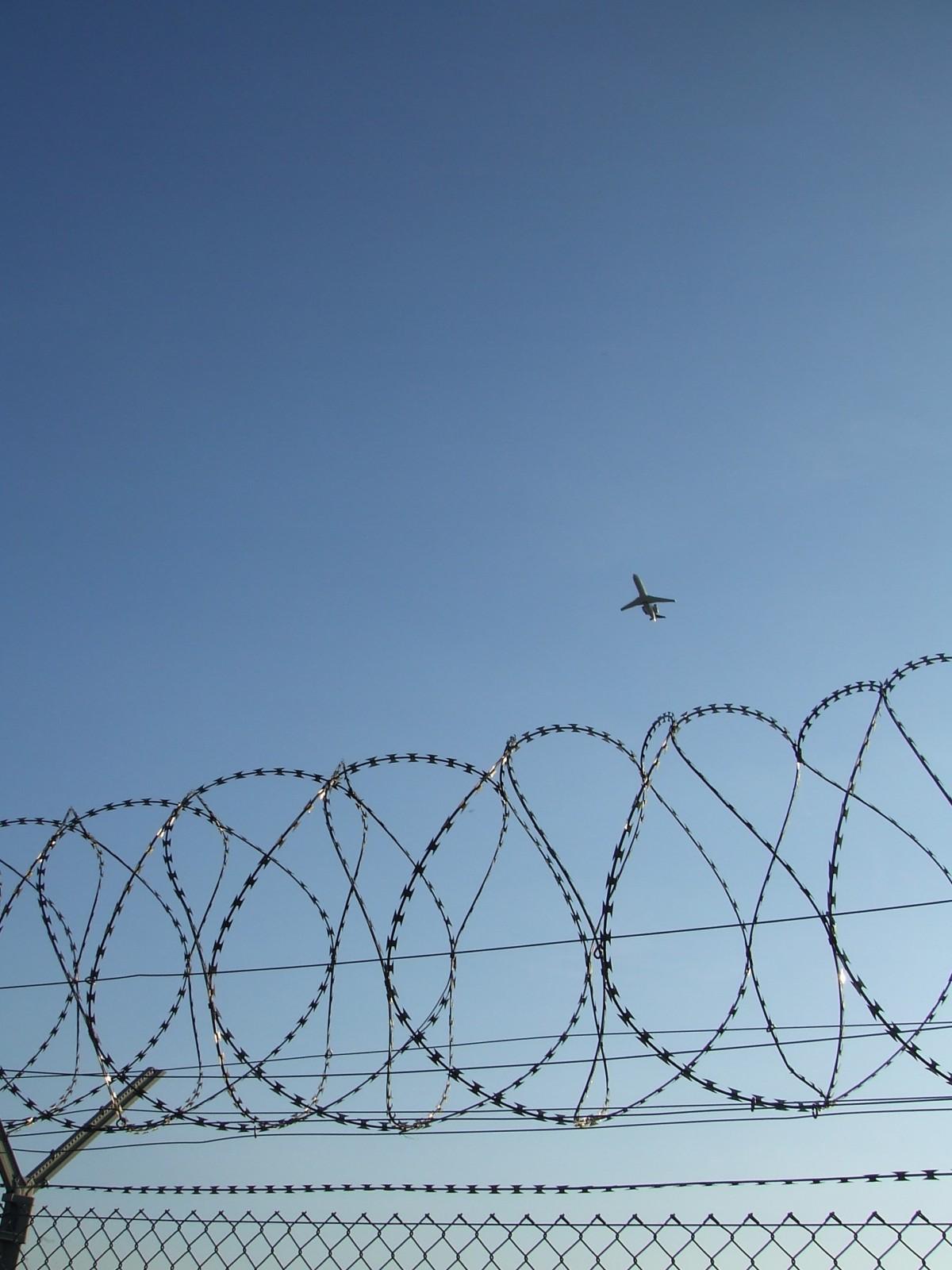 Un avion qui survole des barbelés