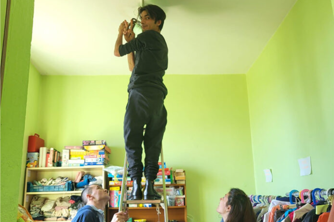 Photo de Naser sur une échelle, prise par son cercle d'ami.es
